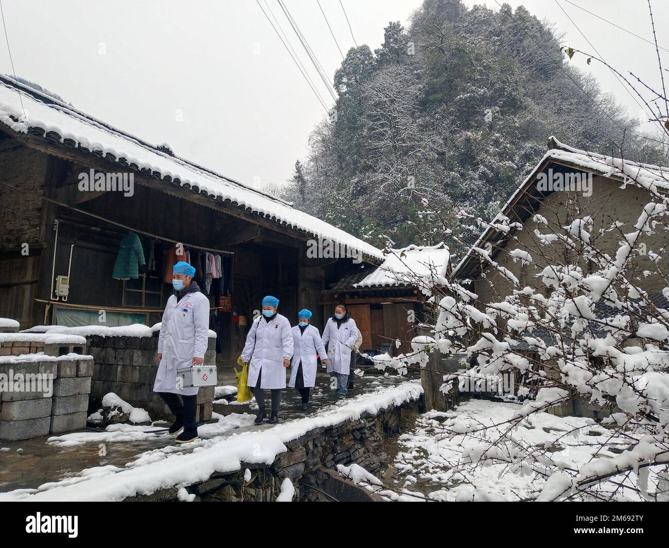 Changsha, Xiangxi Tujia e la Prefettura Autonoma di Miao nella Provincia di Hunan della Cina centrale. 29th Dec, 2022. I medici delle zone rurali visitano le famiglie locali per fornire assistenza medica nel comune di Jiwei nella contea di Huayuan, Xiangxi Tujia e nella prefettura autonoma di Miao nella provincia di Hunan della Cina centrale, il 29 dicembre 2022. PER ANDARE CON 'caratteristica: I medici di base cruciali nella lotta anti-COVID della Cina' accreditamento: Jian Biao/Xinhua/Alamy Live News Foto Stock