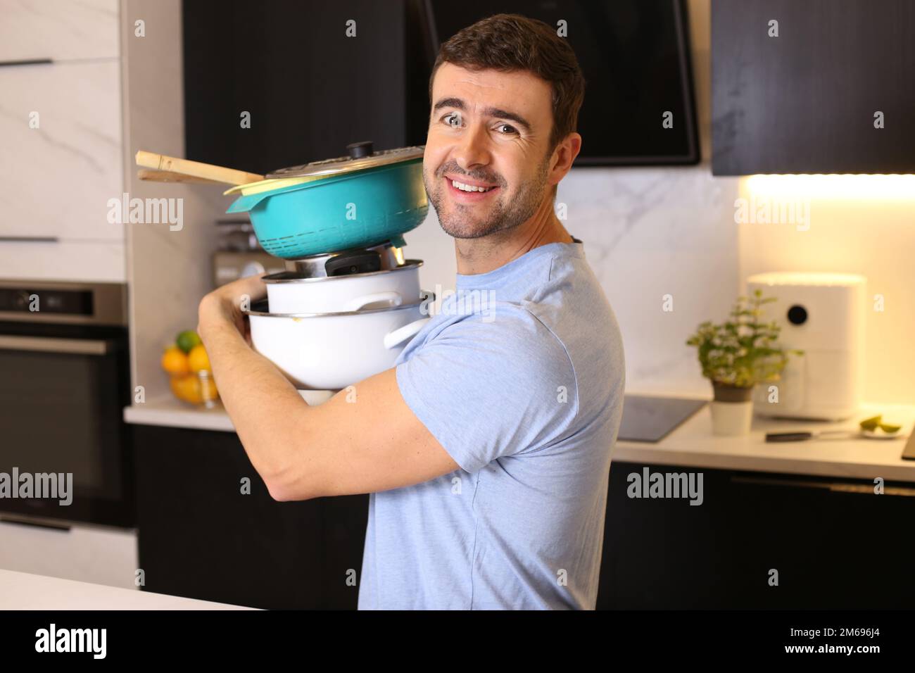 Uomo che cerca di organizzare la sua cucina Foto Stock