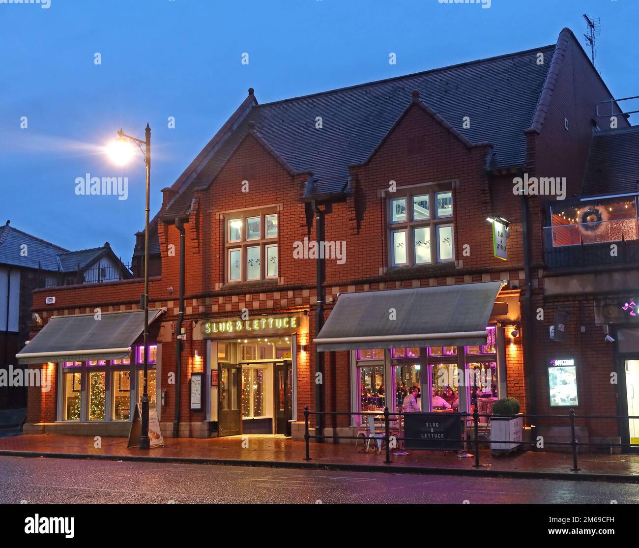 Slug & Lettuce, Natale a Victoria Square, Stockton Heath, Warrington, Cheshire, Inghilterra, UK, WA4 2AF, crepuscolo con albero e decorazioni Foto Stock