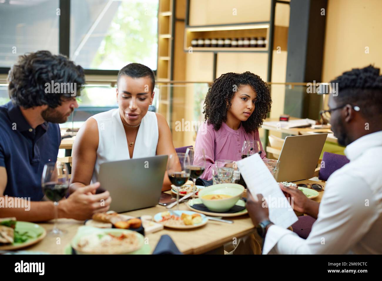 I lavoratori aziendali che si riuniscono in un ristorante durante il pranzo. Foto Stock