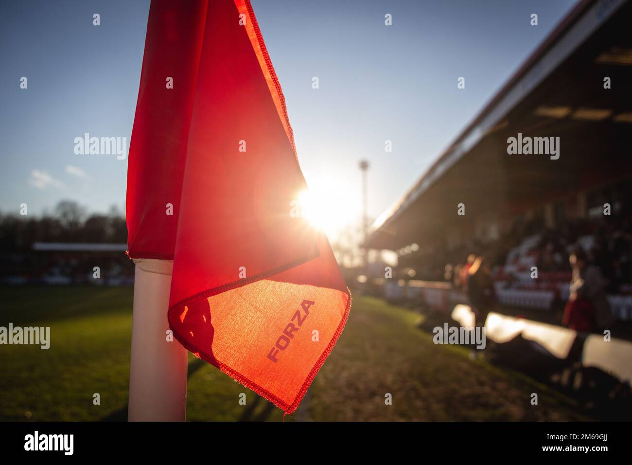 Primo piano della bandiera d'angolo al campo di calcio della bassa lega nel Regno Unito contro il tramonto. Foto Stock
