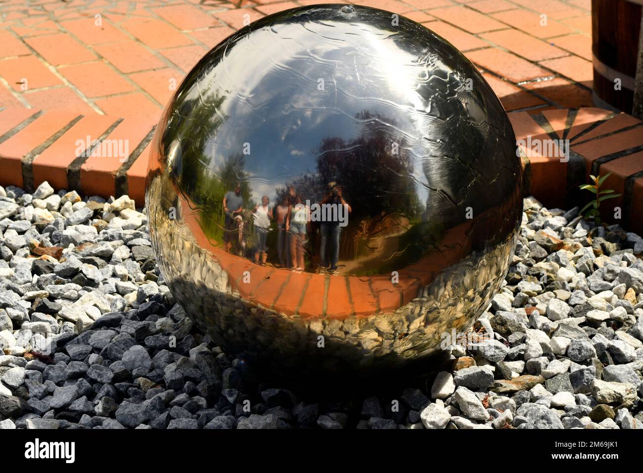 Schiltern, Austria - 08 agosto 2022: Foto di gruppo in una palla di metallo con acqua nel giardino avventura Kittenberger un'oasi con innumerevoli piante, Foto Stock