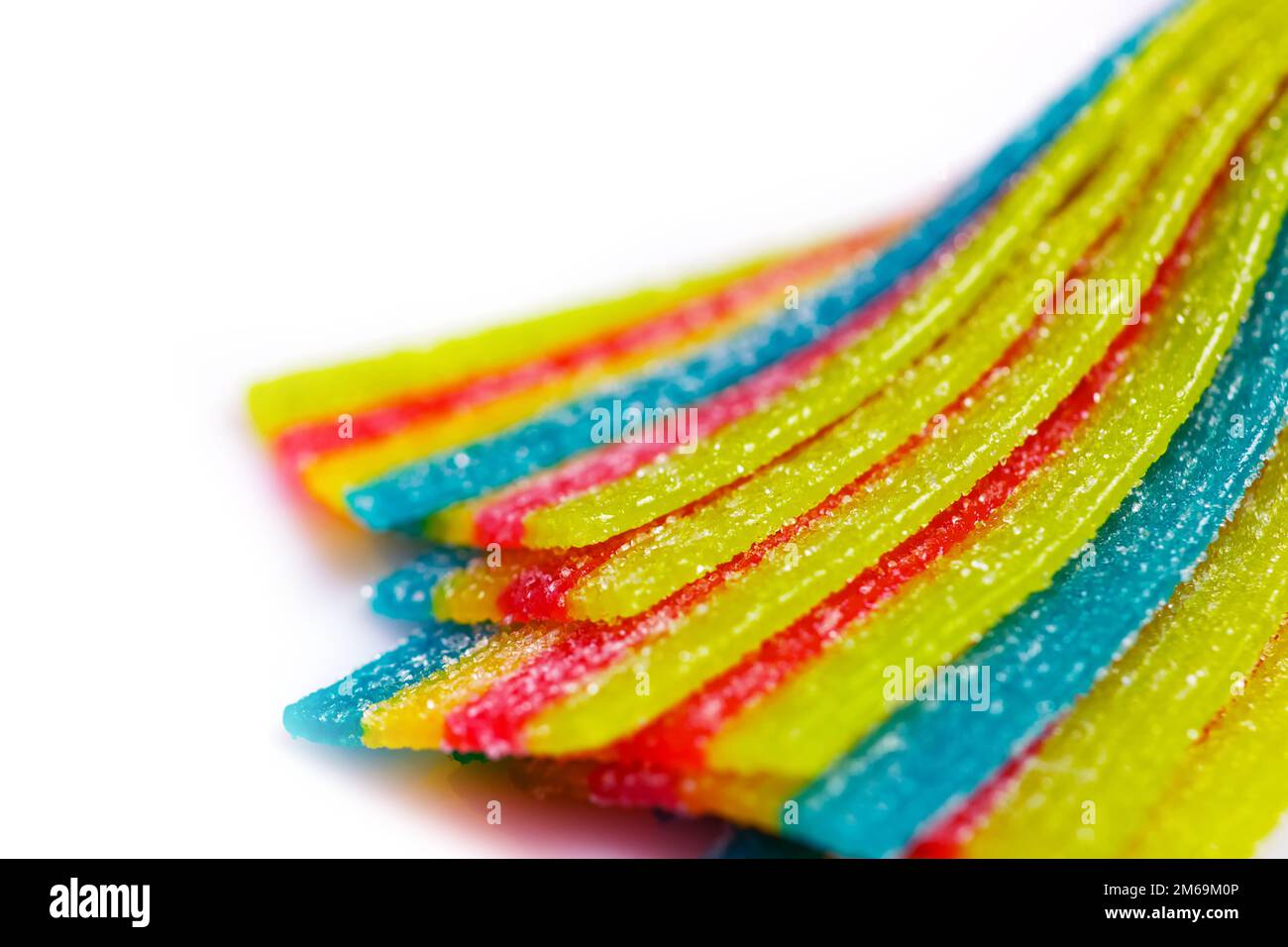 strisce di caramelle arcobaleno in gelatina acidata in zucchero cosparso su  fondo bianco Foto stock - Alamy