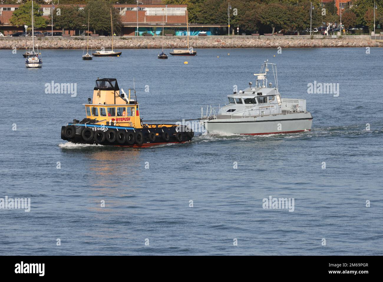 Il rimorchiatore WYEPUSH traina l'ex-Royal Navy pattuglia SCIMITAR dal porto Foto Stock