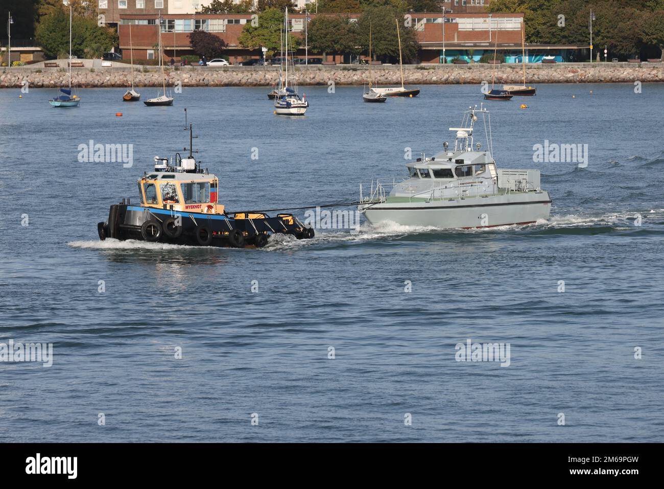 Il rimorchiatore WYEKNOT traina l'ex-Royal Navy pattuglia SABER fuori dal porto Foto Stock