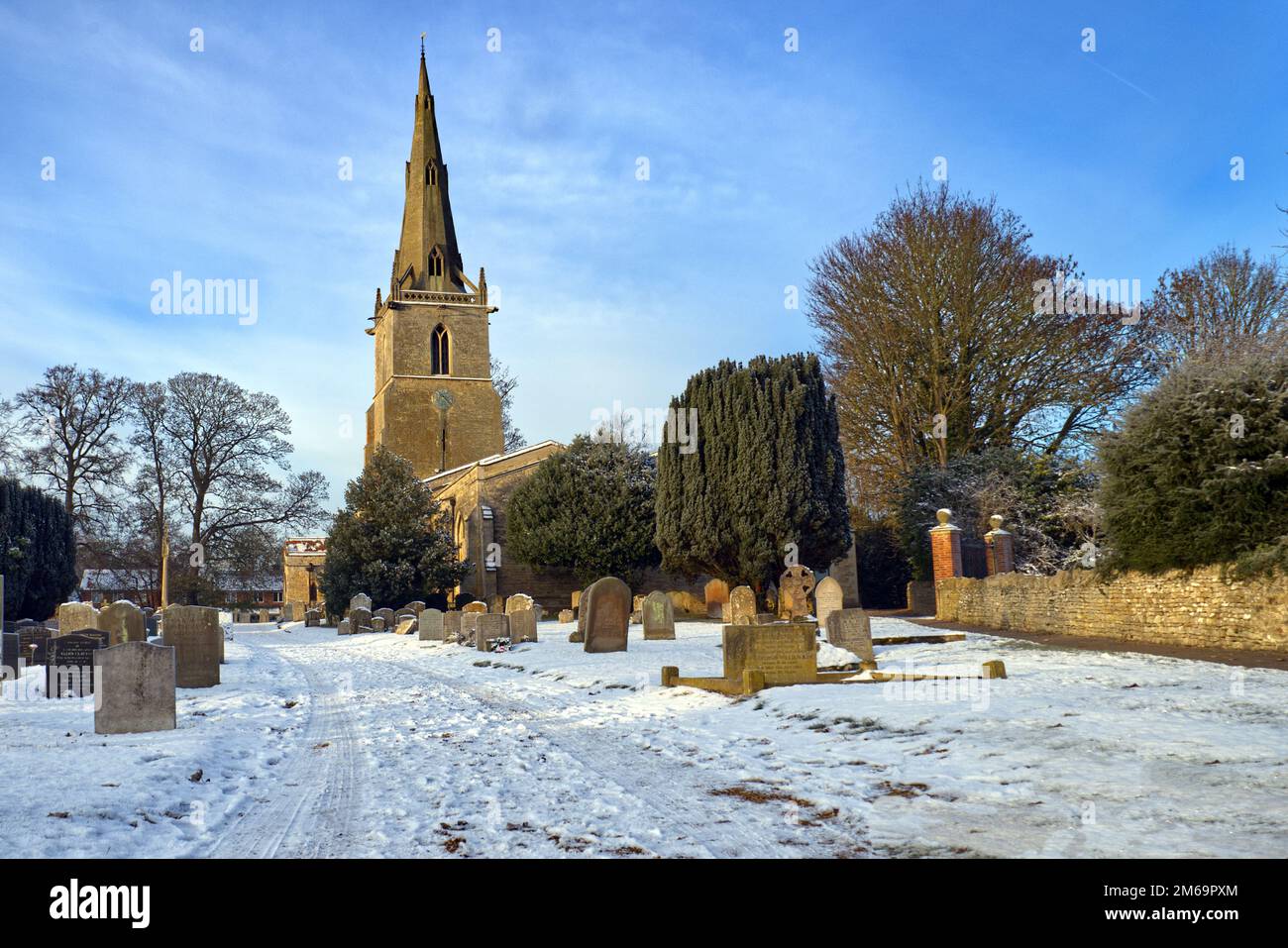 Bedfordshire, Inghilterra, Regno Unito - Chiesa di San Pietro e cimitero nel villaggio di Sharnbrook dopo la neve invernale Foto Stock