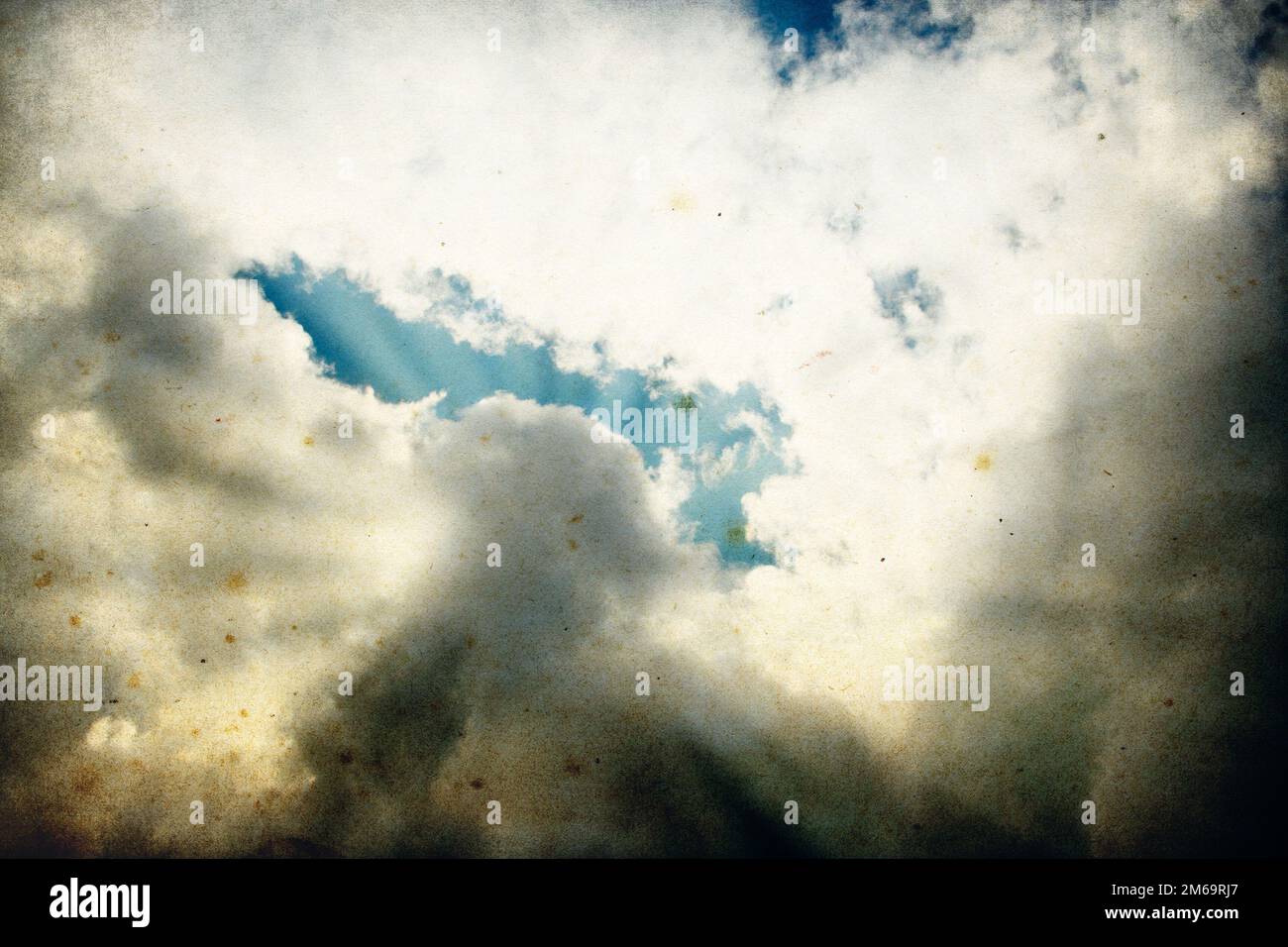 Nuvole e un cielo blu con raggi solari che brillano, utile come elemento di sfondo nei lavori di progettazione. Foto Stock