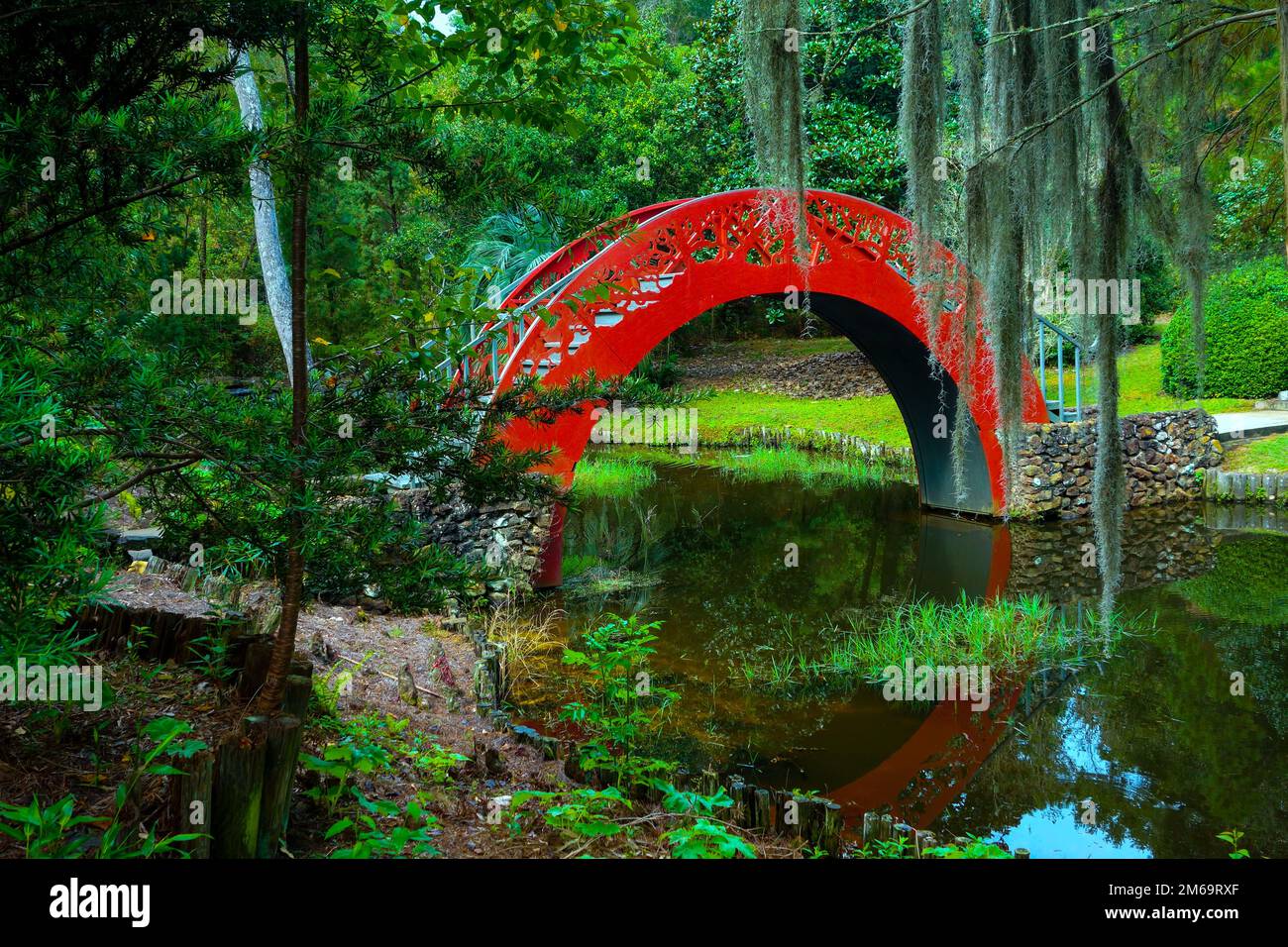 Ponte sulla Luna Rossa con riflessione nei giardini di Bellingath Foto Stock