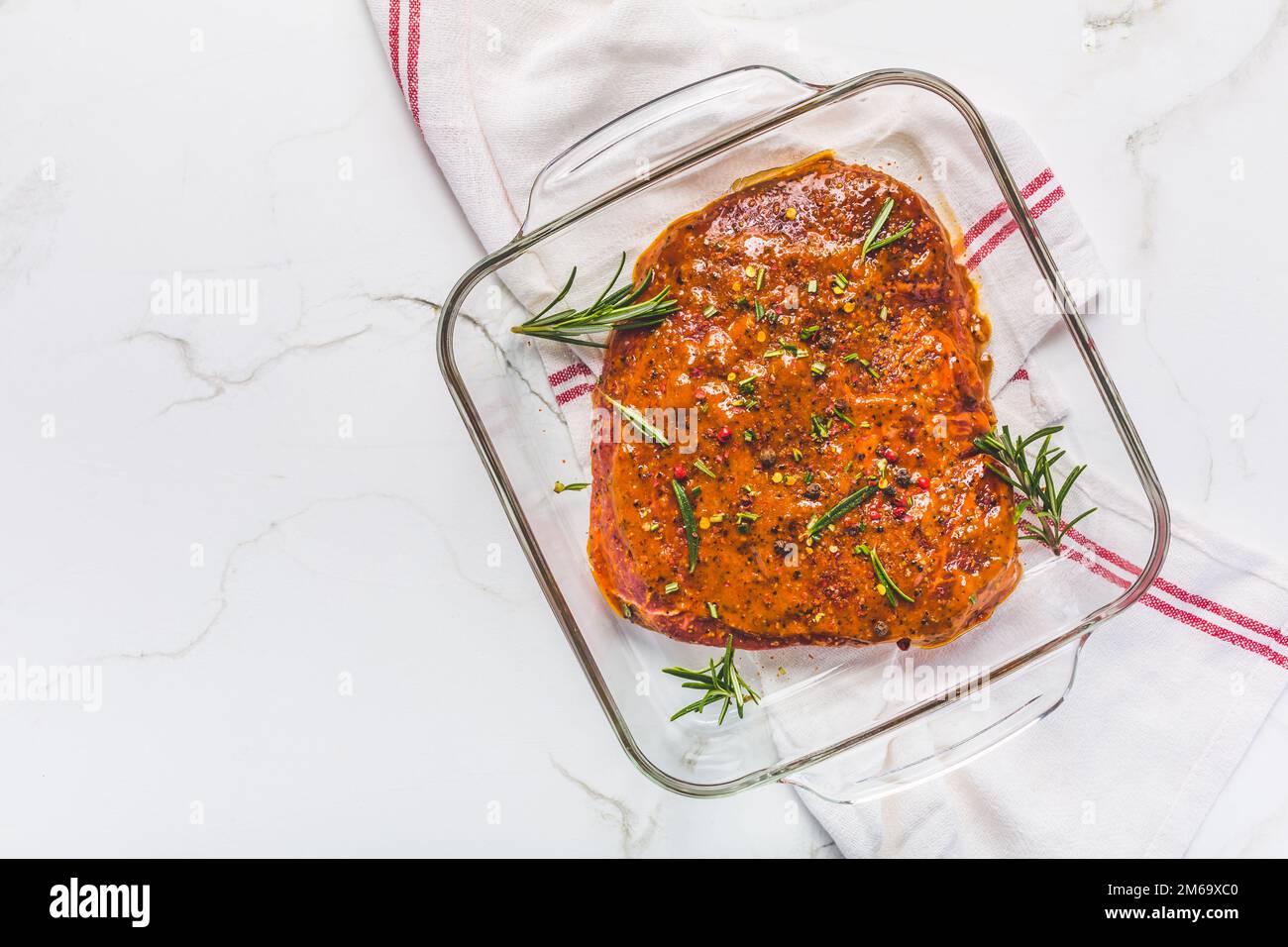 Classica bistecca di manzo marinata in ciotola sul tavolo da cucina bianco Foto Stock