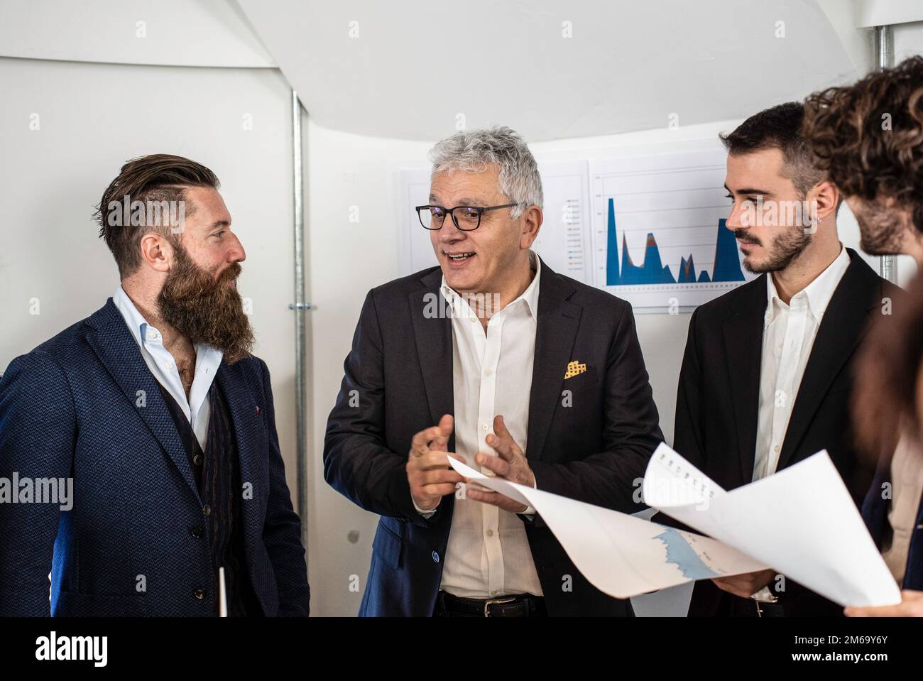 L'uomo d'affari senior spiega ai colleghi le direttive necessarie per raggiungere gli obiettivi aziendali in un ufficio moderno - filtro luminoso con attenzione al bu senior Foto Stock