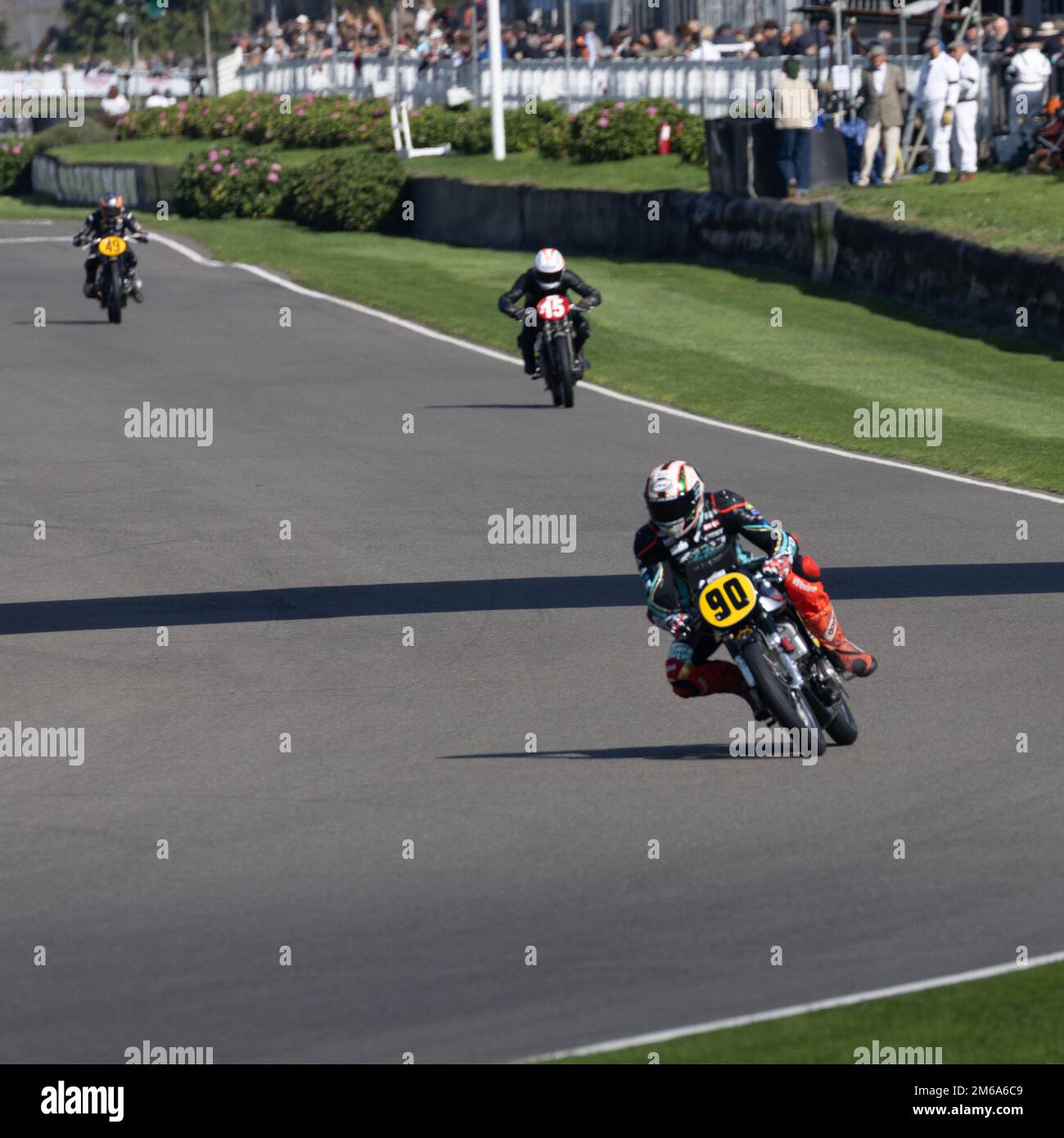 La moto n.90 conduce altri due in curva alla Goodwood Revival 2022 Foto Stock