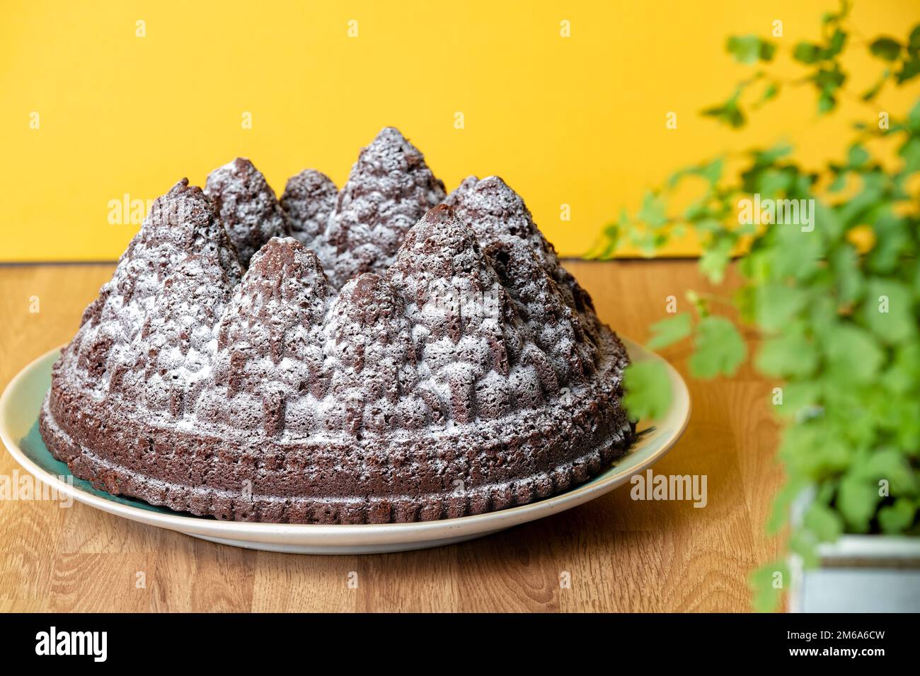 Una torta natalizia al cioccolato. La torta viene fatta usando una teglia per formare la pastella per torte nelle forme dell'albero. Una spruzzata di zucchero a velo lo supera Foto Stock