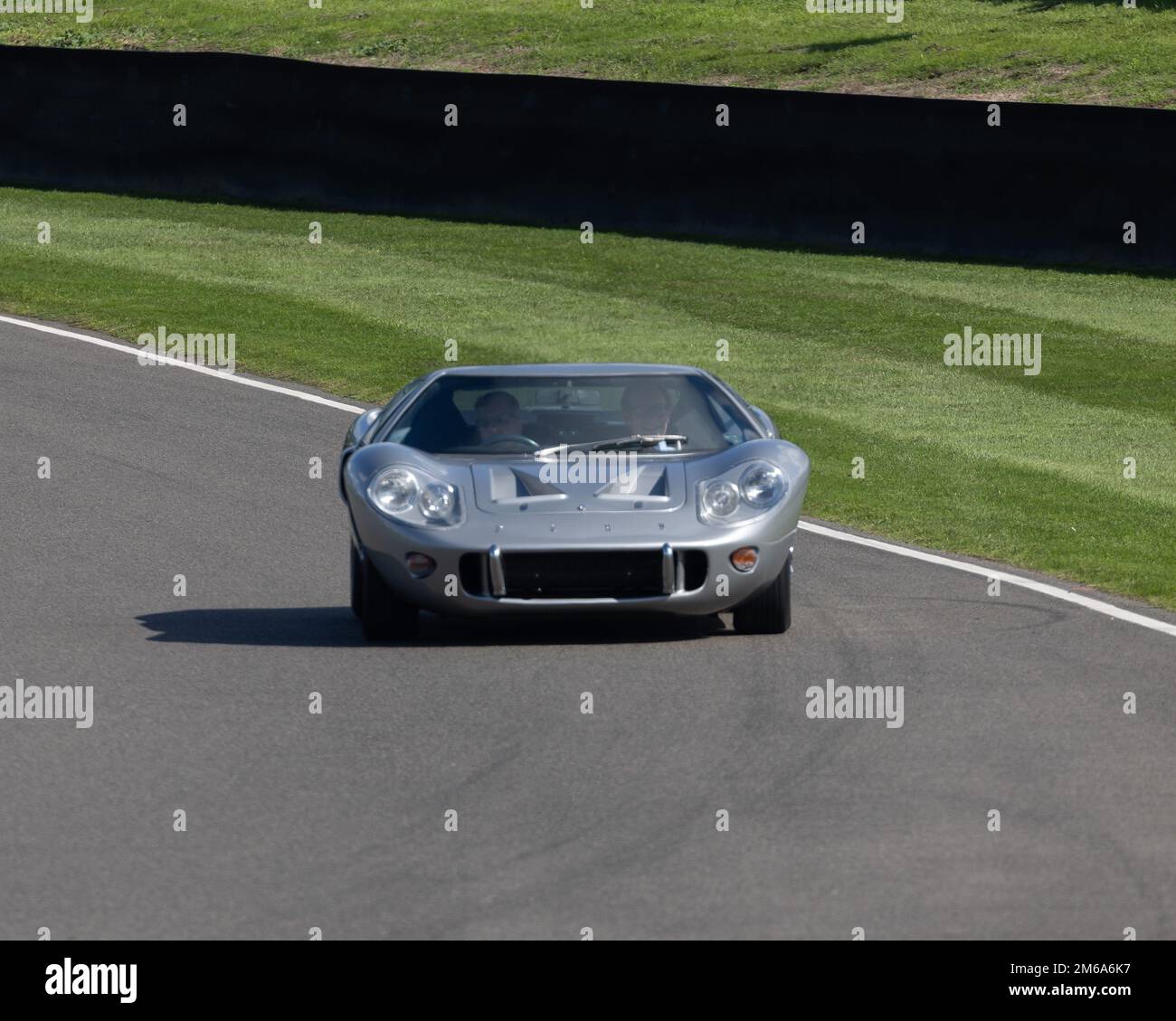 Una berlina verde Jaguar 1958 conduce una ford GT40 al Goodwood Revival 2022 Foto Stock