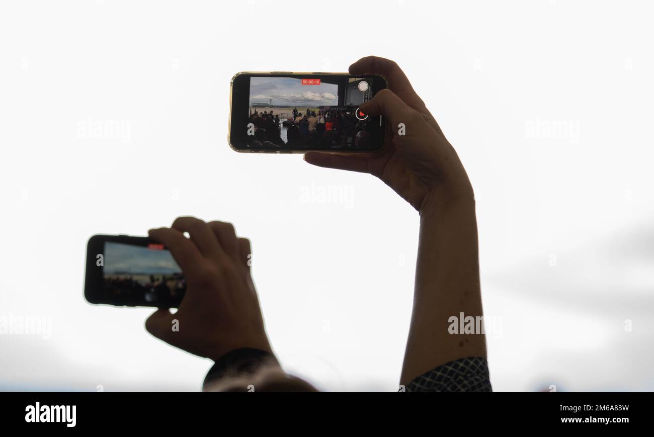 I telefoni vanno fino come Stati Uniti Presidente, Joe Biden entra nel Rosenbaum Hangar presso la base della Guardia Nazionale aerea di Portland, OREE. Per una conferenza stampa il 21 aprile 2022. Il Presidente ha colto l'occasione per parlare dei futuri investimenti nelle infrastrutture e dei miglioramenti che verranno a Portland nel prossimo futuro. Foto Stock