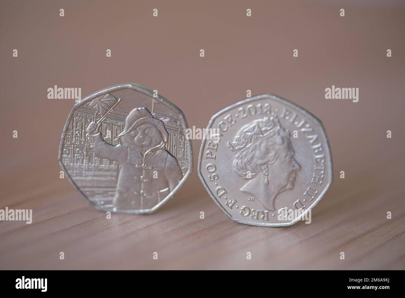 Due pezzi da 50p pezzi con la regina Elisabetta II e l'orso di Paddington che sventola una bandiera Foto Stock