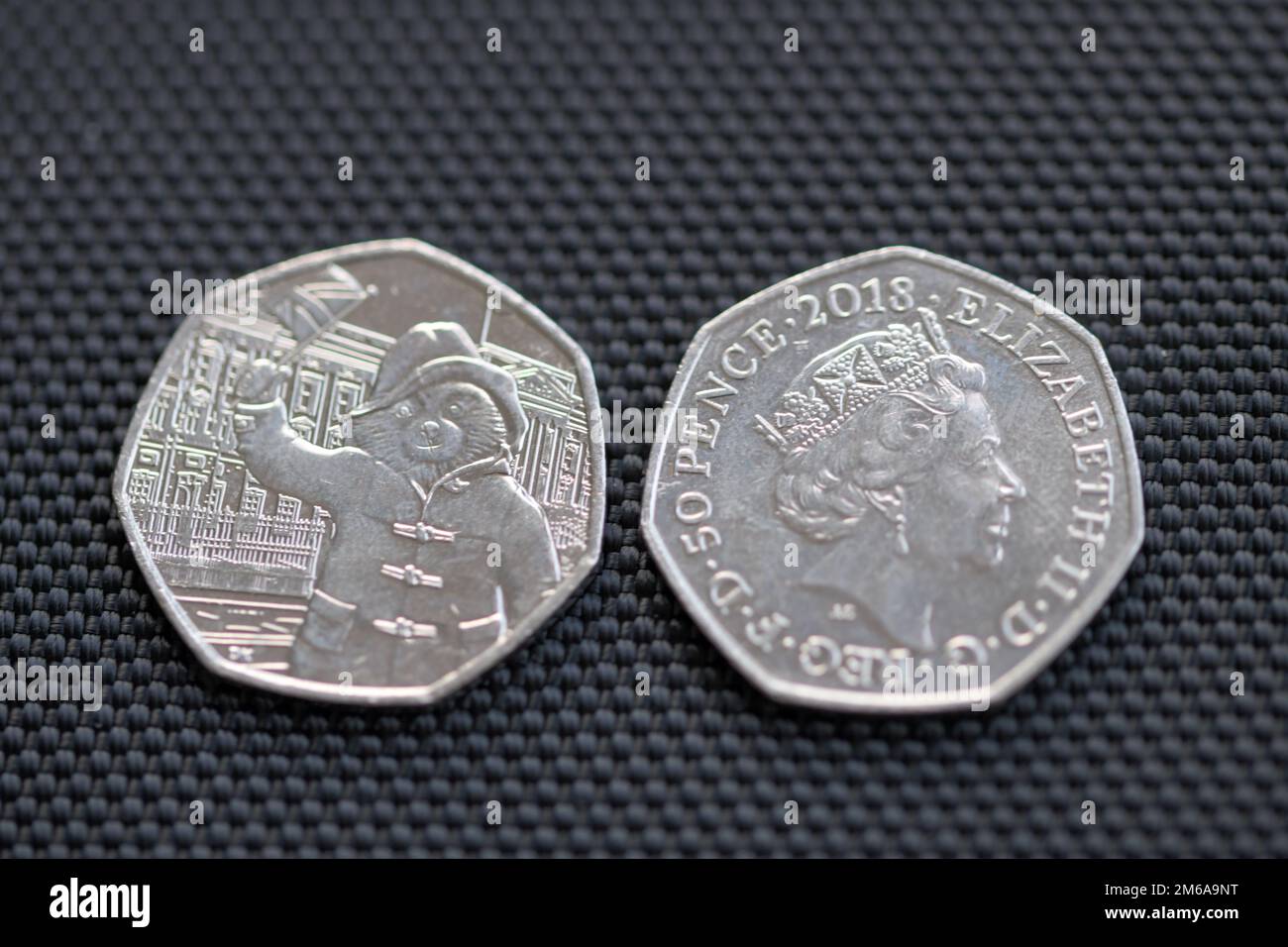Due pezzi da 50p pezzi con la regina Elisabetta II e l'orso di Paddington che sventola una bandiera Foto Stock