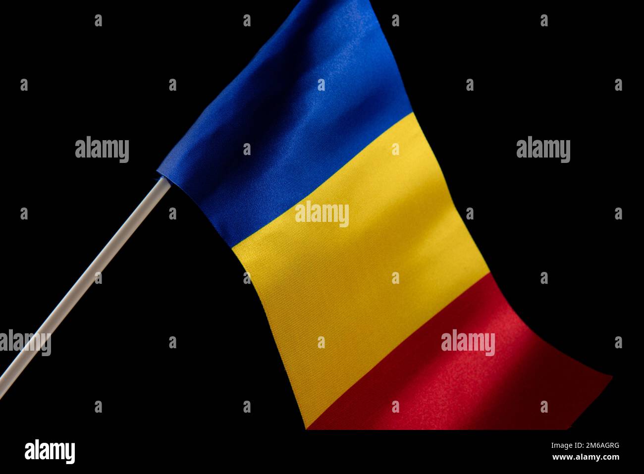 La bandiera rumena su uno sfondo nero che si sviluppa nel vento Foto Stock