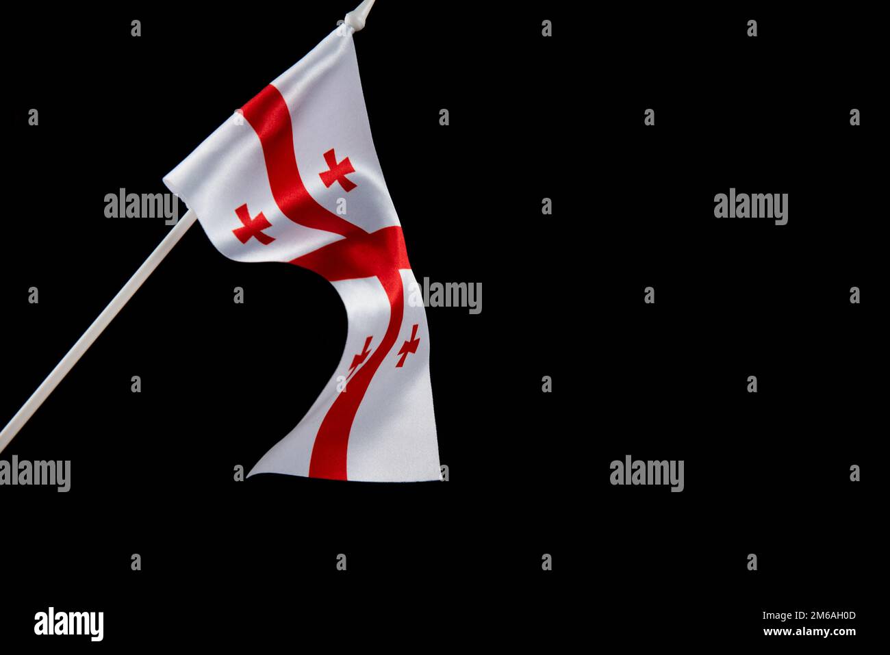La bandiera della Georgia su uno sfondo nero si sviluppa e vola ondeggiando nel vento Foto Stock
