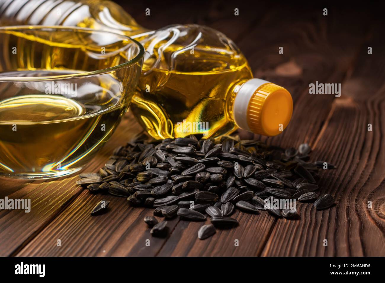 Olio di girasole biologico in una ciotola di vetro e bottiglia con semi di girasole Foto Stock