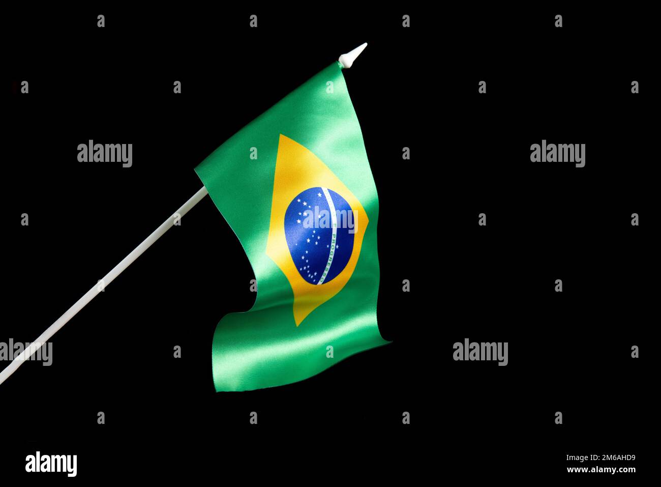 La bandiera brasiliana su uno sfondo nero che si sviluppa e che sbatte nel vento Foto Stock