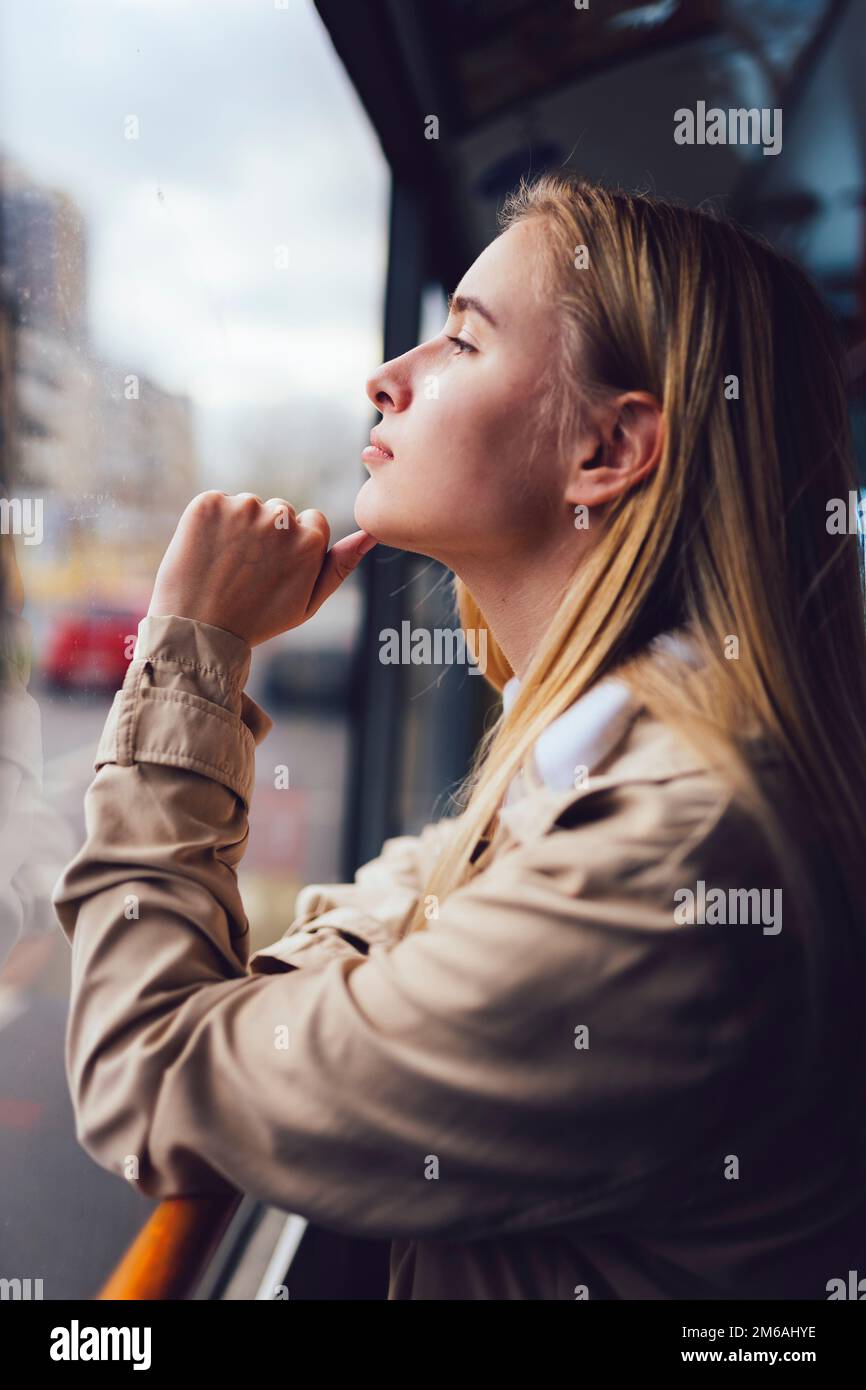 giovane donna con i mezzi pubblici che guarda fuori dalla finestra Foto Stock