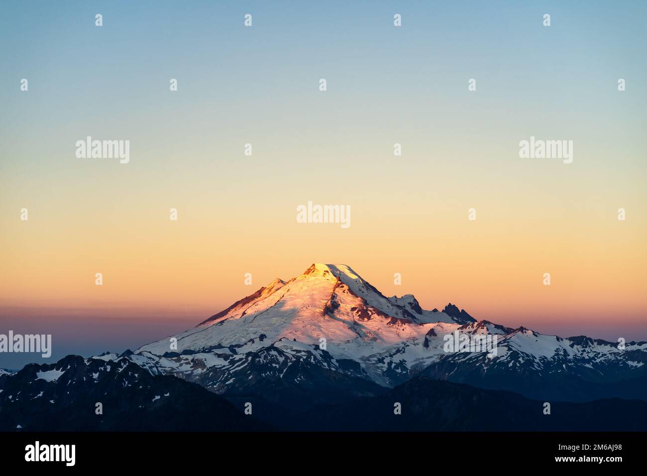 Sole che sale toccando il Monte Baker Foto Stock
