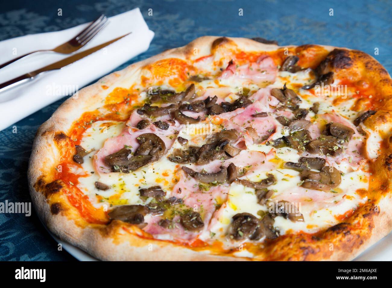 Funghi e prociutto pizza. Pizza napoletana con salsa di pomodoro, formaggio, prosciutto, funghi e verdure. Autentica ricetta italiana. Foto Stock
