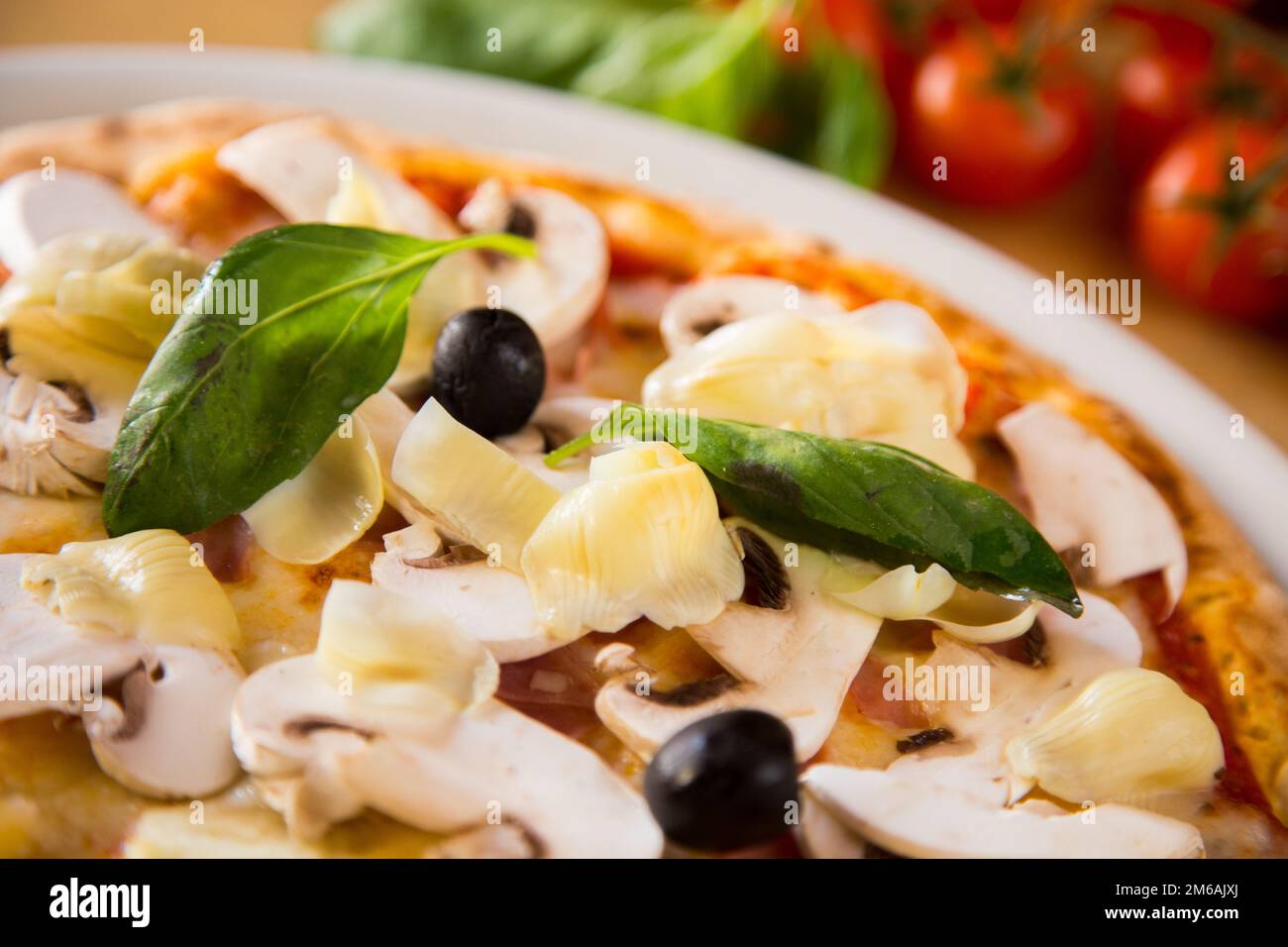 Funghi e prociutto pizza. Pizza napoletana con salsa di pomodoro, formaggio, prosciutto, funghi e verdure. Autentica ricetta italiana. Foto Stock