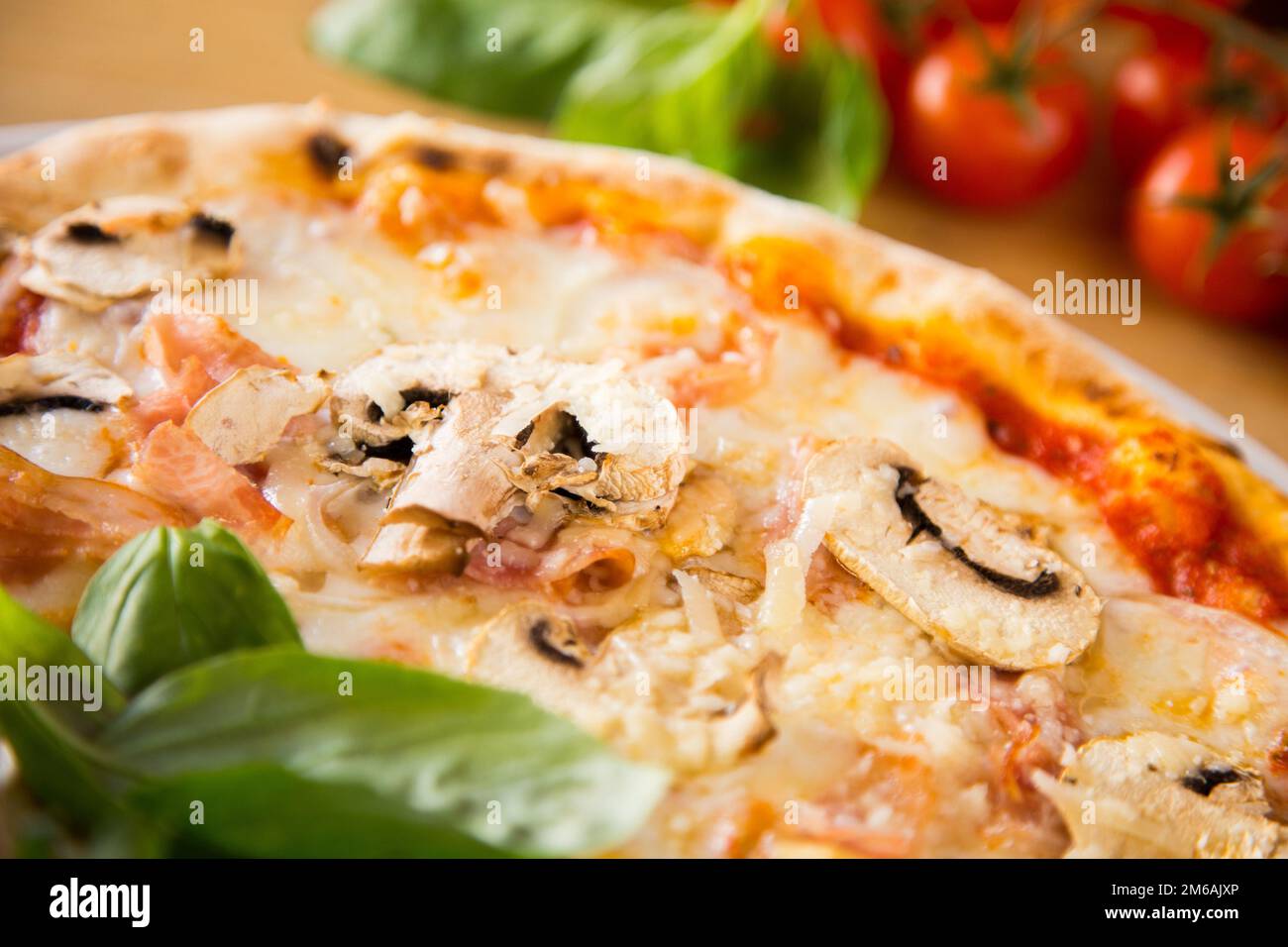 Funghi e prociutto pizza. Pizza napoletana con salsa di pomodoro, formaggio, prosciutto, funghi e verdure. Autentica ricetta italiana. Foto Stock