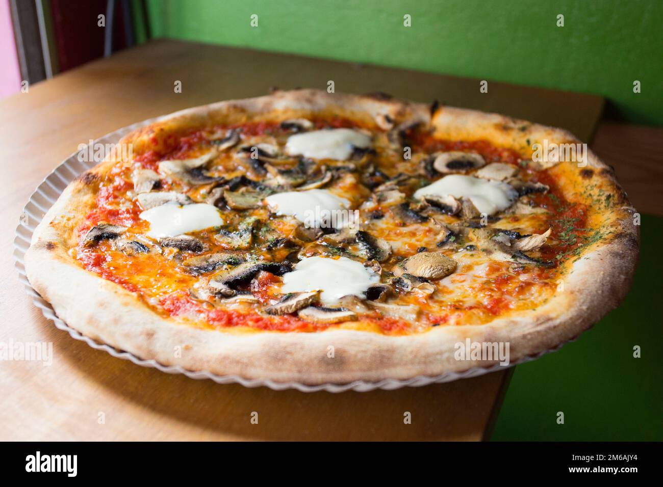 Funghi e prociutto pizza. Pizza napoletana con salsa di pomodoro, formaggio, prosciutto, funghi e verdure. Autentica ricetta italiana. Foto Stock