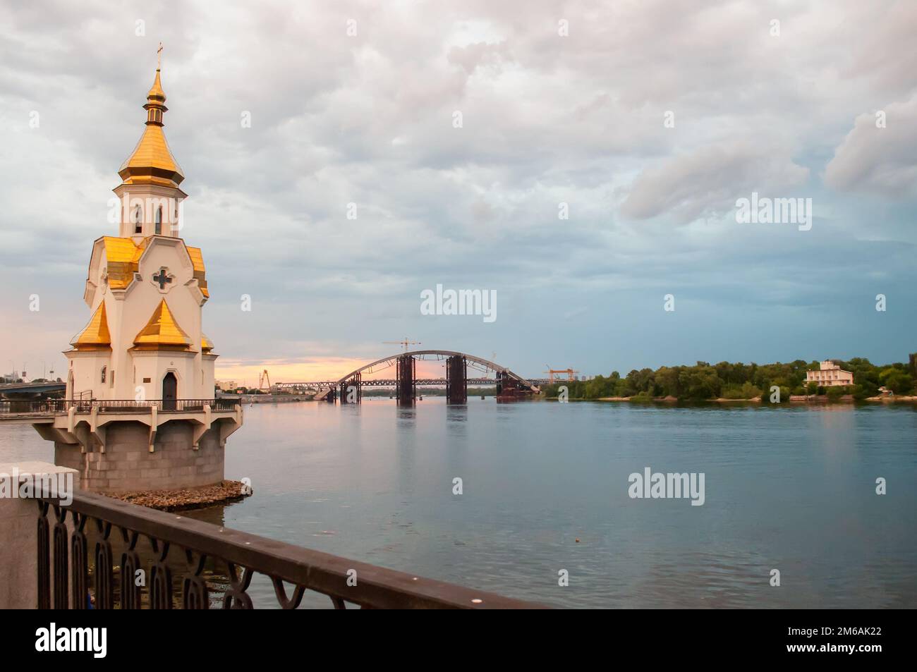 Kiev, Ucraina. Luglio 19. 2014. Vista del Dnieper con una chiesa ortodossa in acqua, un ponte in costruzione sul fiume. Tempo nuvoloso w Foto Stock