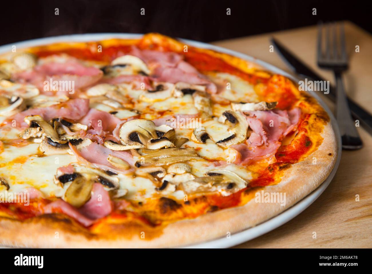 Funghi e prociutto pizza. Pizza napoletana con salsa di pomodoro, formaggio, prosciutto, funghi e verdure. Autentica ricetta italiana. Foto Stock