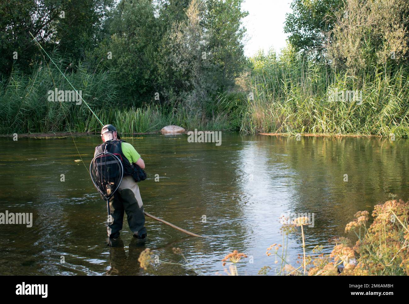 Un uomo che pesca nel fiume Foto Stock