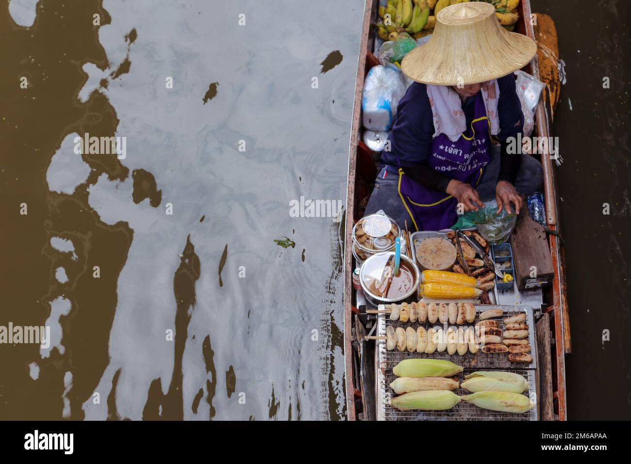 anziana donna tailandese seduta in una piccola barca di legno. Indonesia, Bangkok, mercato galleggiante. Foto Stock