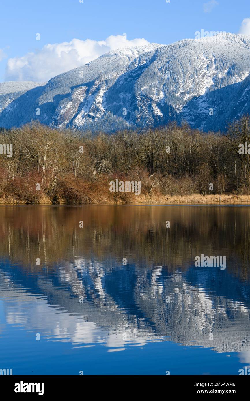 Washington Cascade Moutains coperta di neve che si riflette nel lago sotto il cielo blu Foto Stock