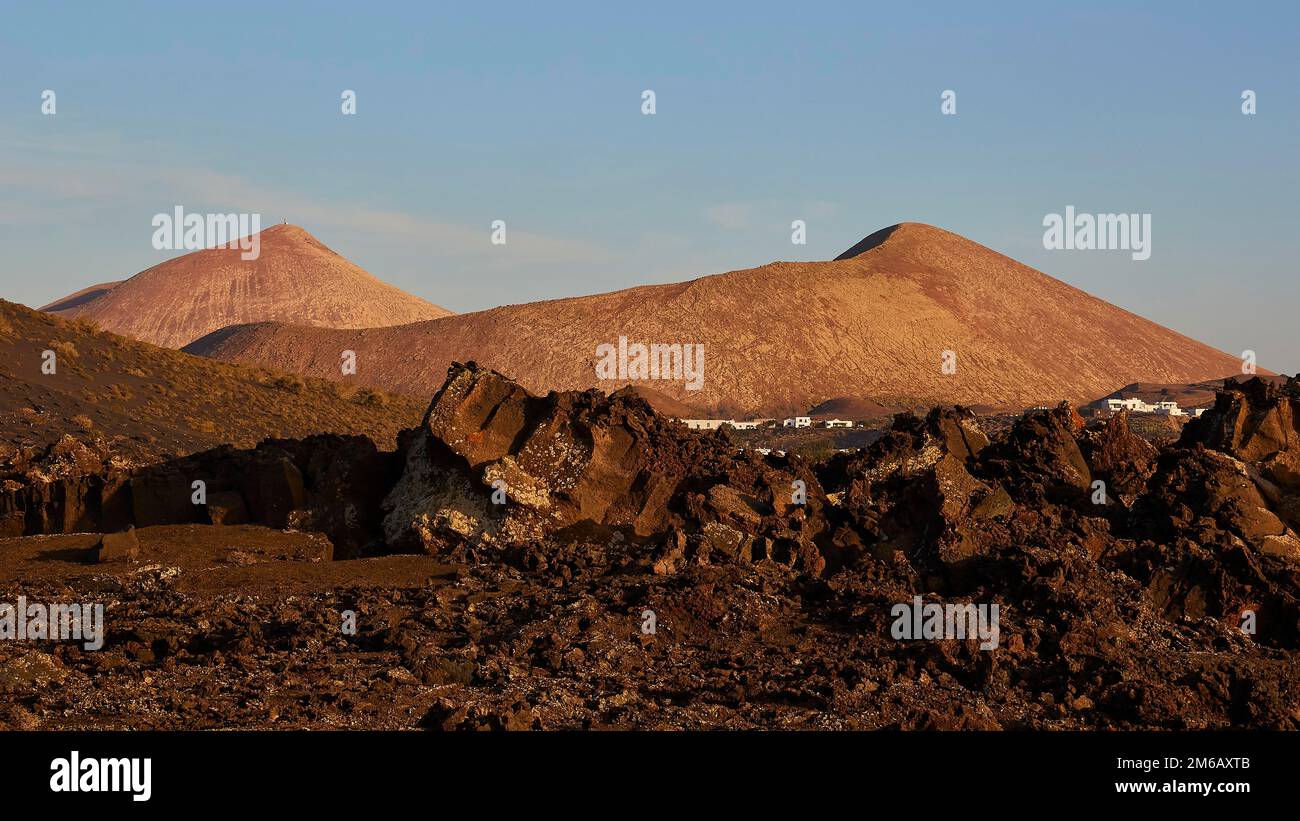 Los Vulcanos, paesaggi di lava con vulcani isolati, terra rosso-marrone, cielo blu, poche nuvole bianche, Lanzarote, Isole Canarie, Spagna Foto Stock