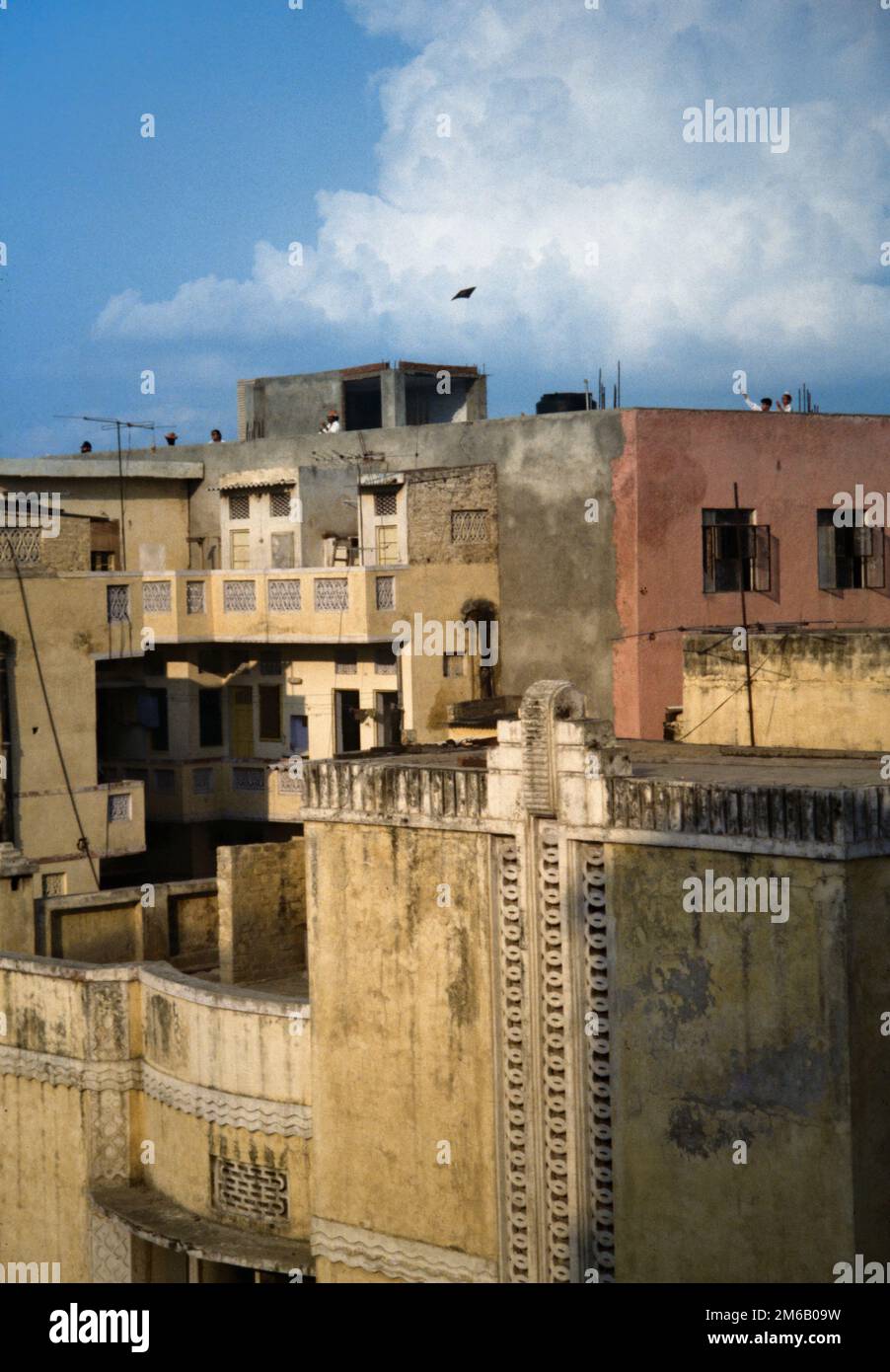 Storico, Archivio Vista di due bambini che volano Un aquilone in cima alle case a Delhi India, agosto 1990 Foto Stock