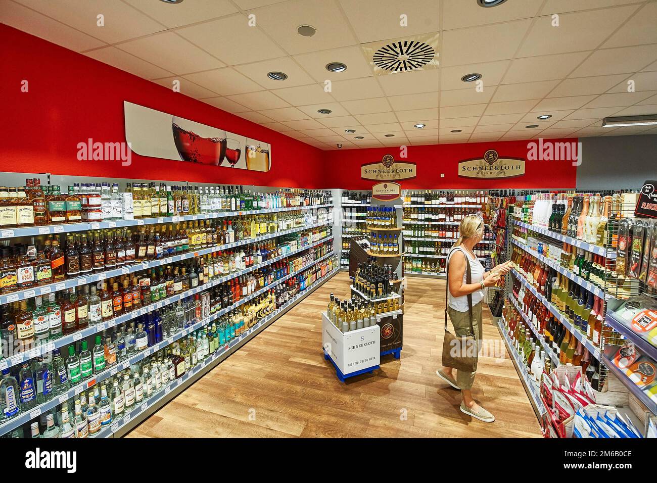 Una donna guarda le merci nel reparto bevande alcoliche, nah&frisch mercato, 24497 Wanderup, bassa Sassonia, Germania Foto Stock