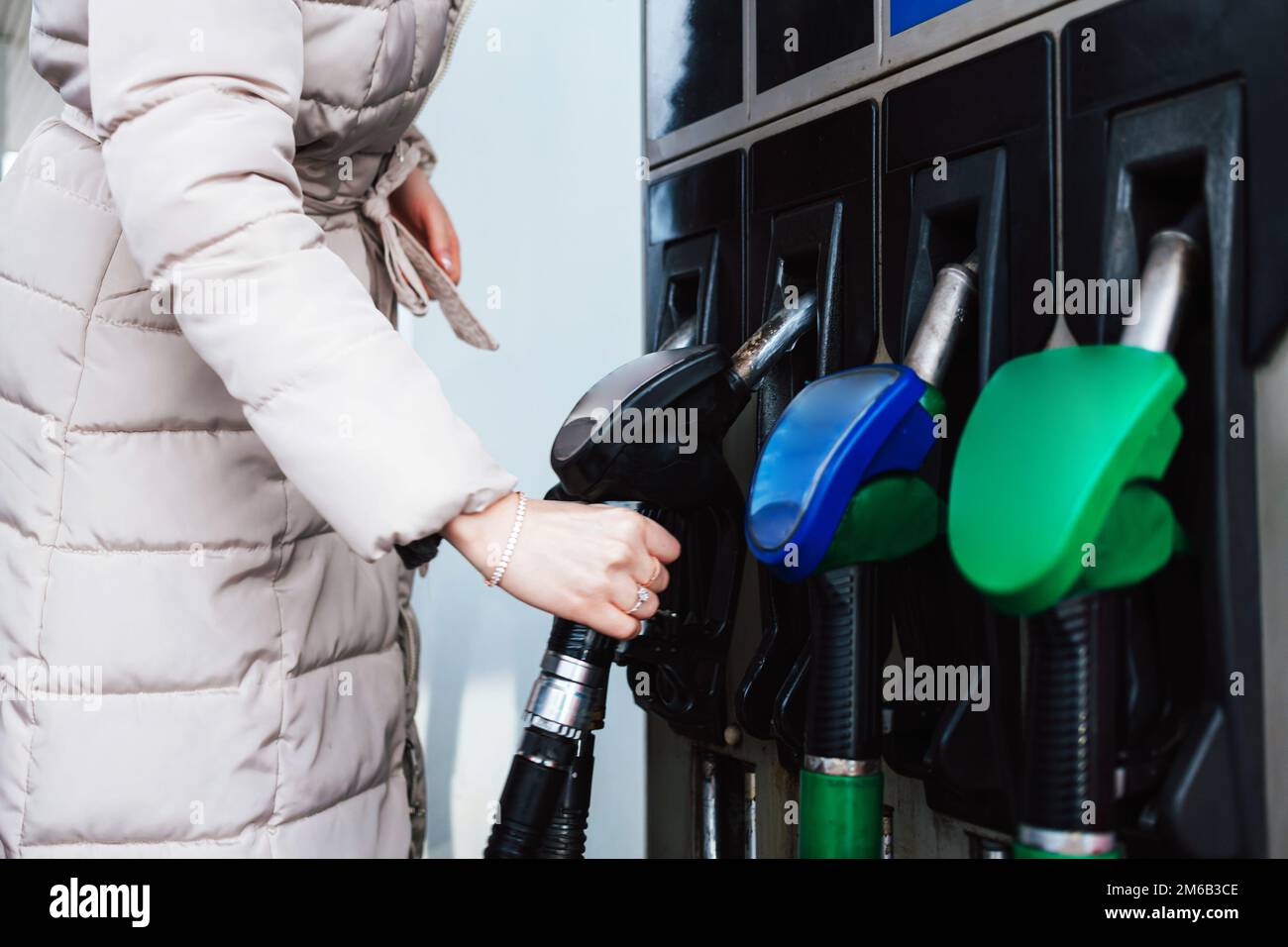 Donna che pompa benzina in auto alla stazione di benzina. Concetto di aumento del prezzo della benzina o della benzina. Foto Stock