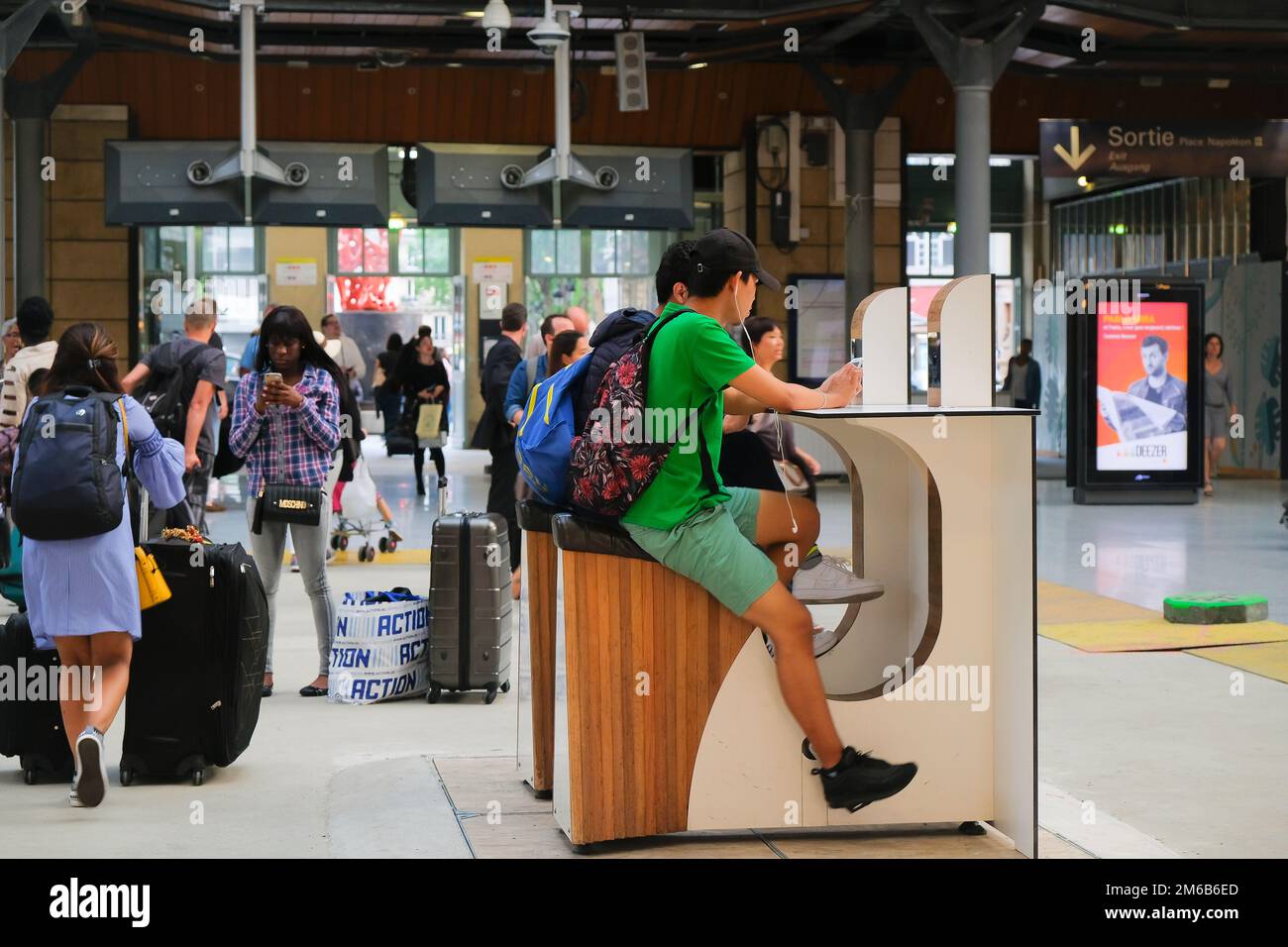 Parigi, Francia - due giovani in bicicletta per caricare i loro telefoni cellulari gratuitamente all'interno della stazione ferroviaria Gare du Nord. Motivazione innovativa all'esercizio fisico. Foto Stock