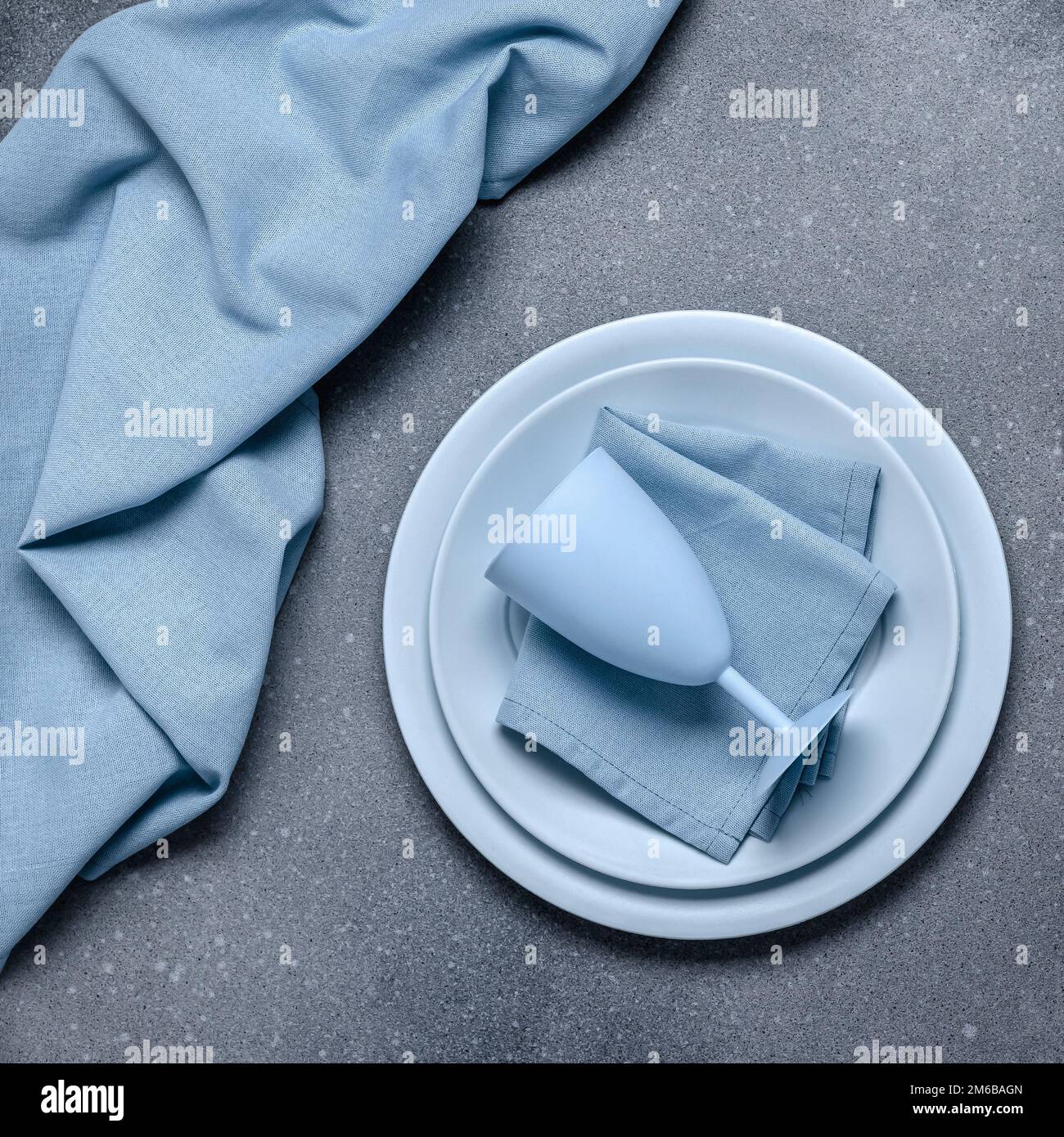 Posizionare l'impostazione con piatti blu. Piastre vuote e tovagliolo su fondo grigio in cemento. Tavolo da pranzo. Scheda vintage o modello di menu, design piatto. Tablewa Foto Stock