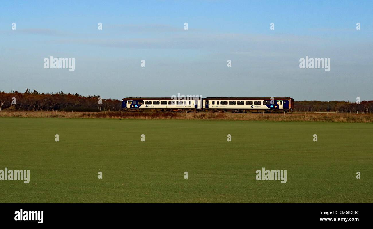 C'è un treno sul prato, un treno nord n. 156 423 attraversa Bescar Moss passando un campo dove il prato è stato coltivato e deve ancora essere sollevato. Foto Stock