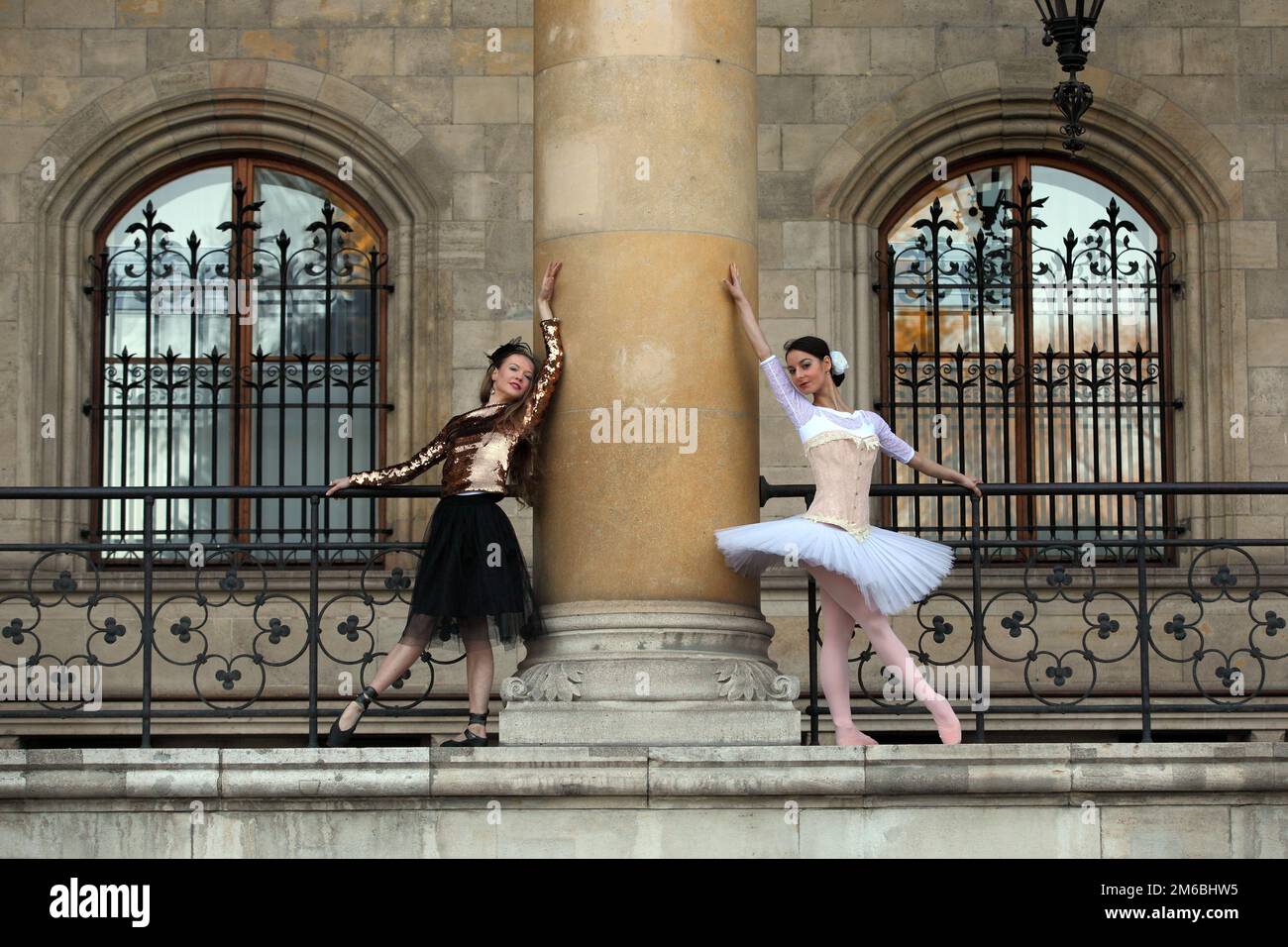 Due belle ballerine che ballano insieme attorno ad una colonna Foto Stock