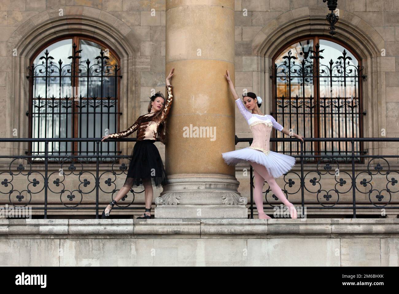 Due belle ballerine che ballano insieme attorno ad una colonna Foto Stock