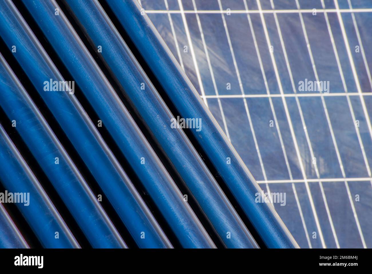 Tubi di riscaldamento solare di fronte a un pannello solare Foto Stock