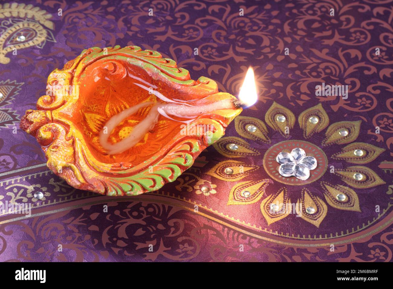 Fatti a mano di argilla Diwali lampada su sfondo floreale Foto Stock
