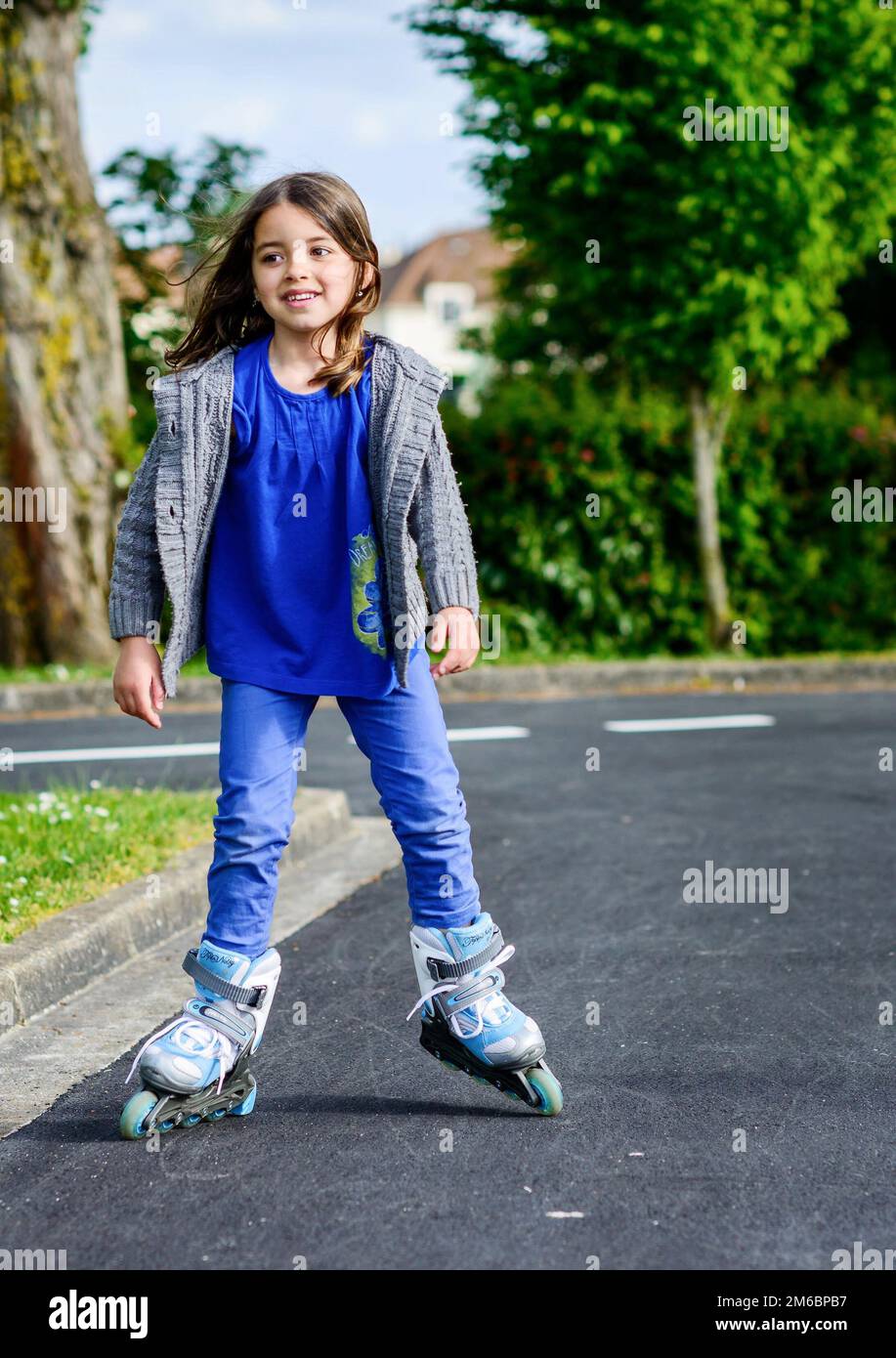Bambina facendo andare in rollerblade in strada Foto Stock