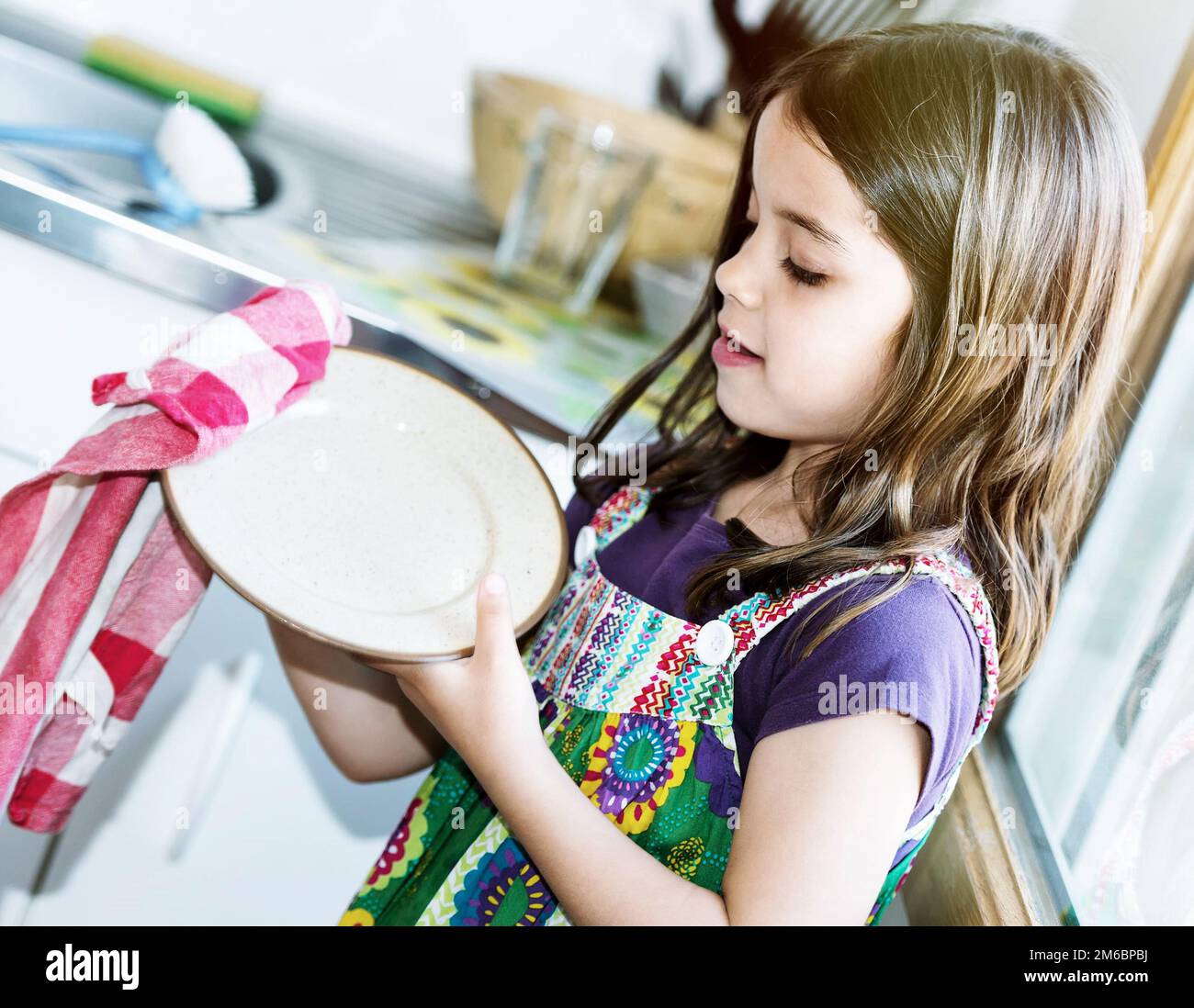 Ragazza molto carina bambino che pulendo i piatti Foto Stock