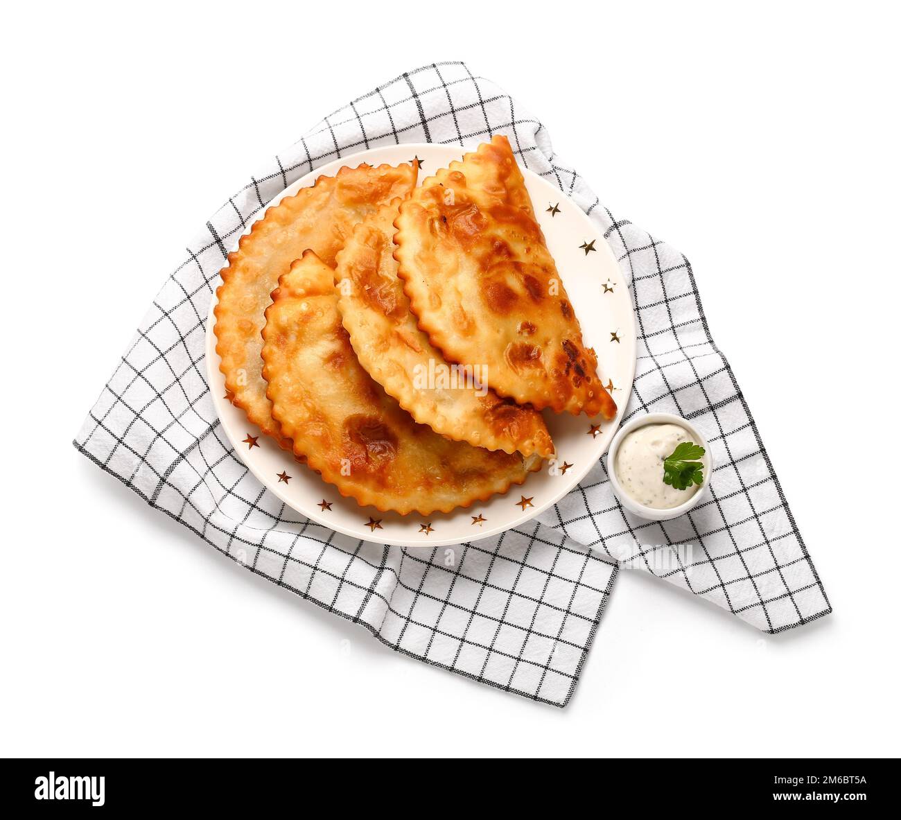 Piatto con gustosi chebureks, salsa e asciugamano da cucina su sfondo  bianco Foto stock - Alamy