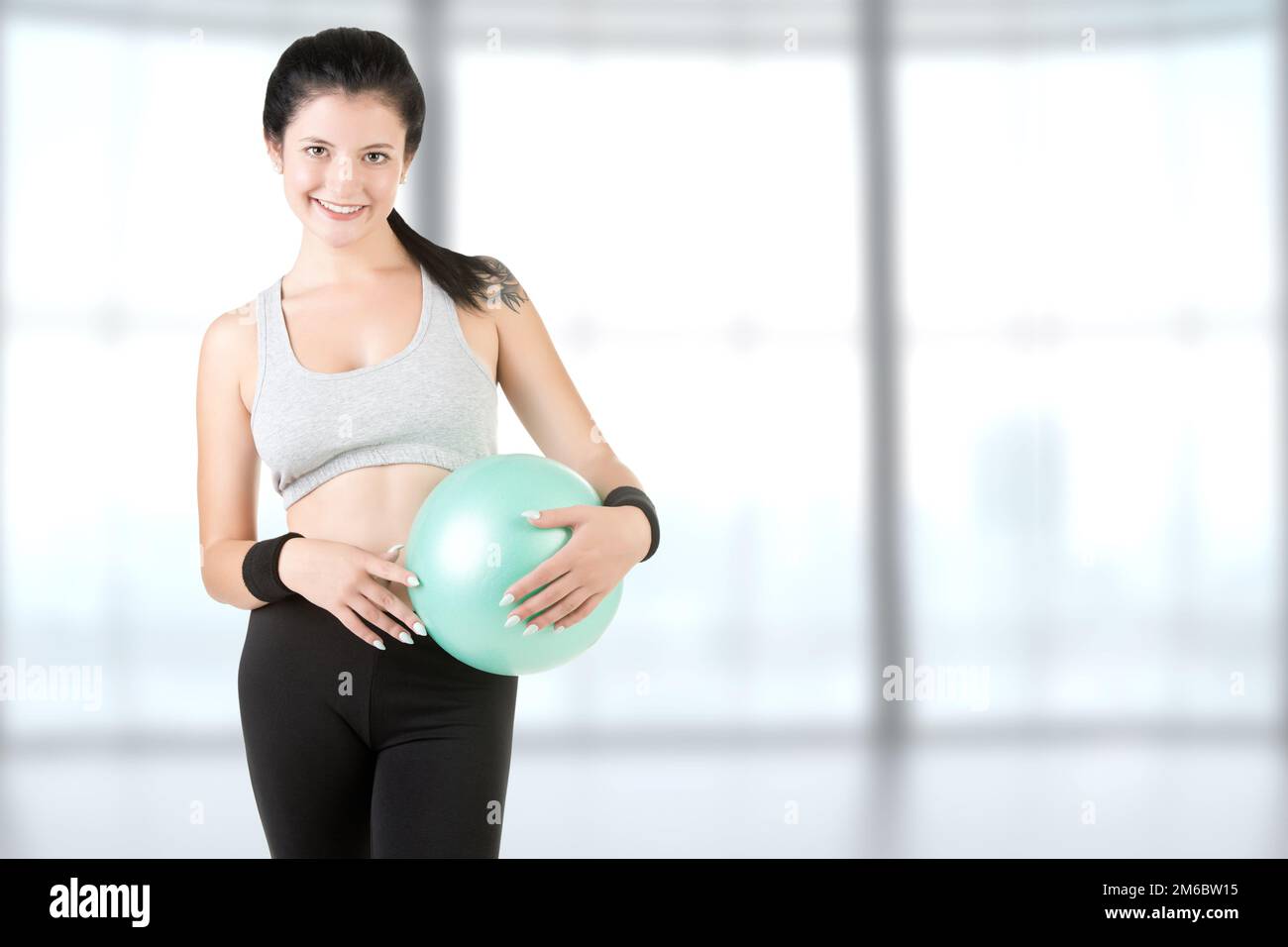 Donna che tiene una palla Pilates Foto Stock